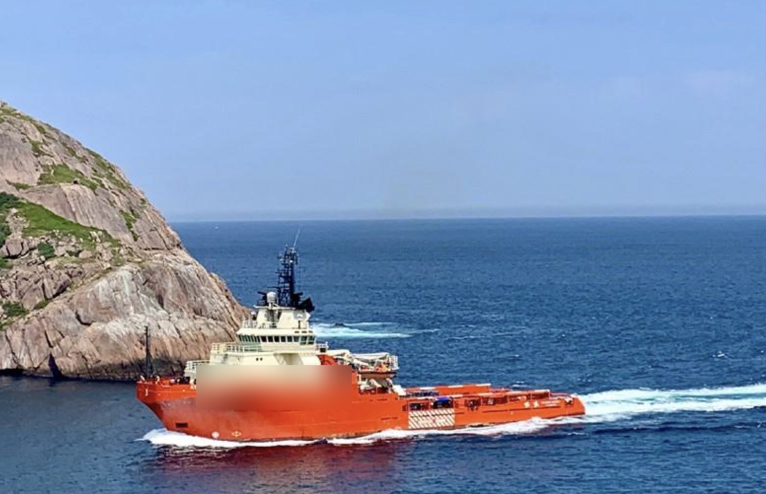 Project Osprey — construction AHTS underway past a headland